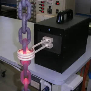 Eine Kette wird durch Induktionserwärmung erhitzt und beginnt zu glühen. Der Prozess zeigt die Anwendung von induktiv erzeugtem elektrischen Strom zur Erwärmung von Metallteilen